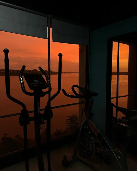 Elípticas y bicis frente a los ventanales al atardecer